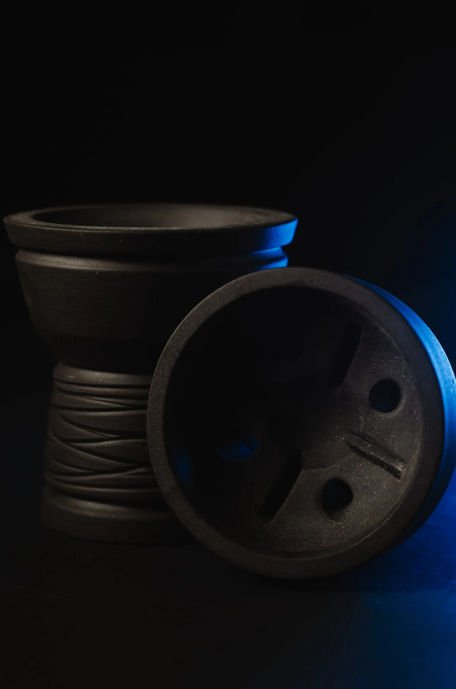 Cazoleta negra con un borde de luz azul sobre fondo negro.